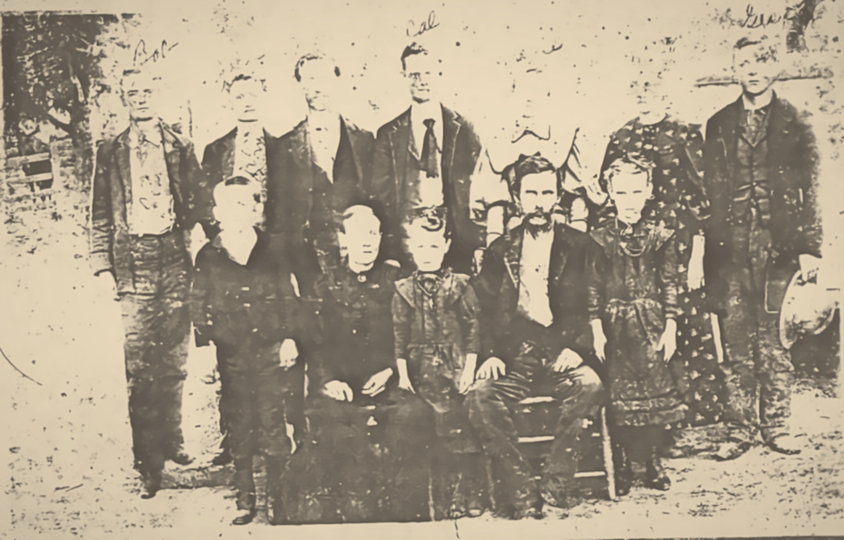 A restored 19th-century family portrait; Houston Henderson, the bearded man seated in the front row, says "You chaps!" in a speech bubble